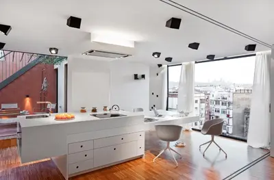 a kitchen with white counters and a large window at DestinationBCN Urgell Apartment in Barcelona