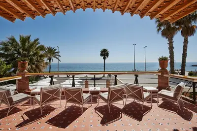 a patio with a table and chairs and the ocean at Hotel Casa Vilella 4* Sup in Sitges