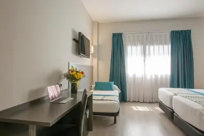 a hotel room with a desk and a bed at Hotel Venture Sant Cugat in Sant Cugat del Vallès
