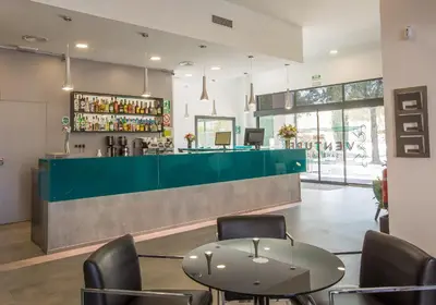 a restaurant with a green counter and chairs at Hotel Venture Sant Cugat in Sant Cugat del Vallès