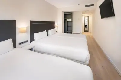 a hotel room with two beds and a television at B&B HOTEL Barcelona Rubí in Rubí