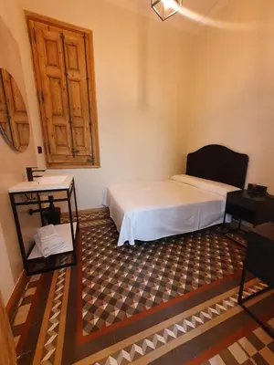 a bedroom with a bed and a wooden door at Hostal Lausanne in Barcelona