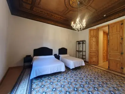 a bedroom with two beds and a chandelier at Hostal Lausanne in Barcelona