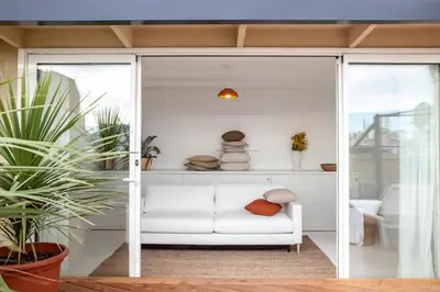 a white couch in a room with sliding glass doors at DestinationBCN Marimon Apartment in Barcelona