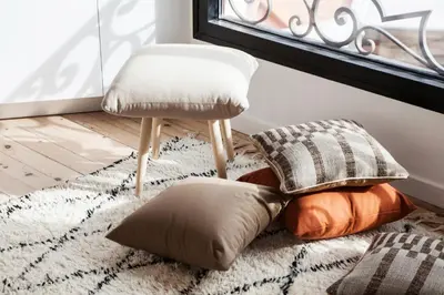 a chair and pillows on a rug next to a window at DestinationBCN Marimon Apartment in Barcelona