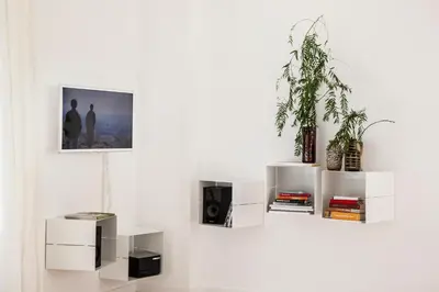 a white wall with white shelves and a plant at DestinationBCN Marimon Apartment in Barcelona