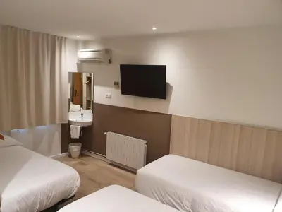 a hotel room with two beds and a flat screen tv at Hostal BESTPRICE Barcelona Stadium in Barcelona