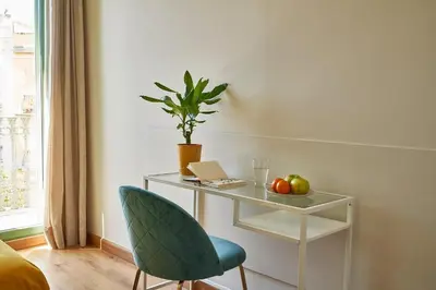 a desk with a chair and a table with a laptop at Barcelona Sants Station Apartments in Barcelona