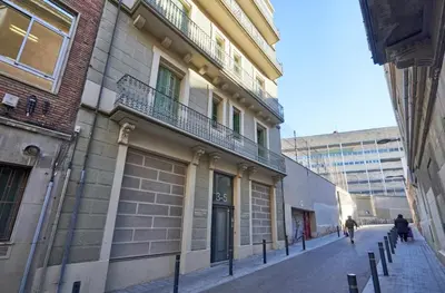 a person walking down a street next to a building at Barcelona Sants Station Apartments in Barcelona