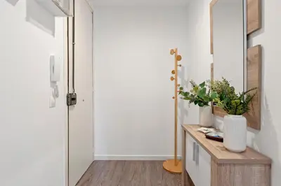 a hallway with a door and a table with flowers at Camp Nou Apartment in Hospitalet de Llobregat