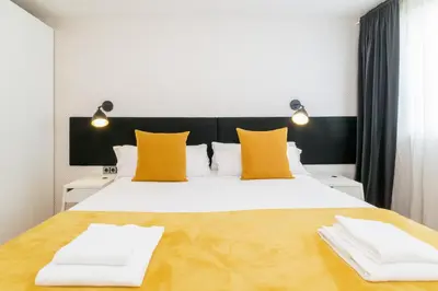 a bedroom with a large white bed with yellow pillows at Unique Rentals - Placa Catalunya Central Apartments in Barcelona