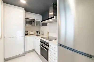 a kitchen with white cabinets and a refrigerator at Unique Rentals - Placa Catalunya Central Apartments in Barcelona