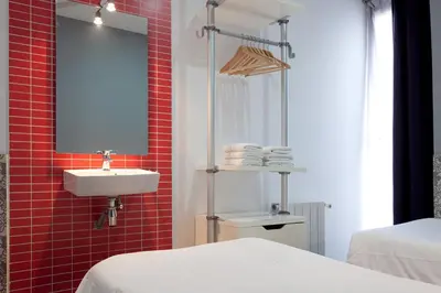 a bathroom with a sink and a red tiled wall at Hostal Nitzs Bcn in Barcelona
