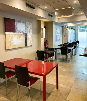 a dining room with a red table and chairs at SM Hotel Sant Antoni in Barcelona