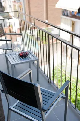 a chair and a table on a balcony at Eric Vökel Boutique Apartments - BCN Suites in Barcelona