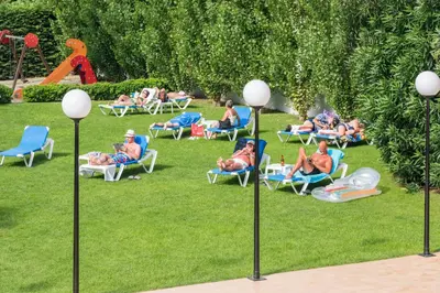 a group of people sitting in chairs in the grass at Hotel Sorrabona in Pineda de Mar