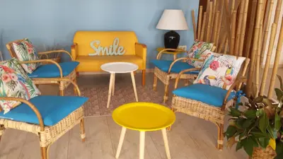 a room with chairs and a yellow chair and a table at Hotel Sorrabona in Pineda de Mar