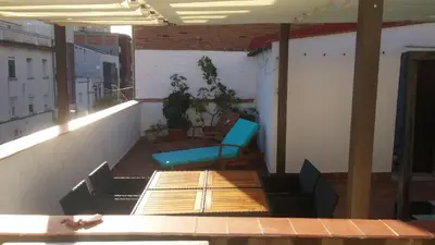 a balcony with a blue chair and a table at LG Big Flat Barcelona in Badalona
