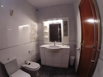 a white bathroom with a toilet and a sink at LG Big Flat Barcelona in Badalona