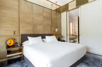 a bedroom with a large white bed and a bathroom at Almanac Barcelona in Barcelona