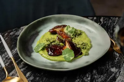 a plate of food with meat and broccoli on a table at Almanac Barcelona in Barcelona
