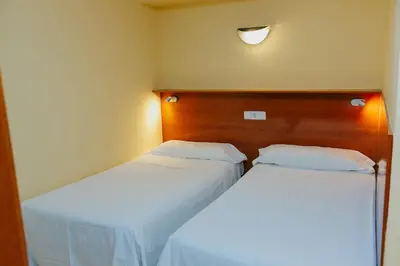 two beds in a hotel room with at Aparthotel Bertrán in Barcelona