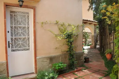 a white door with ivy on the side of a house at Tibidabo Apartments in Barcelona