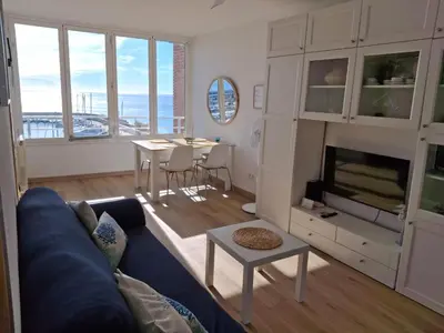 a living room with a blue couch and a table at Candela's Beach Port in Masnou