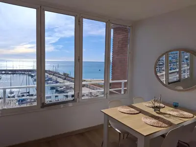 a dining room with a table and a view of the ocean at Candela's Beach Port in Masnou