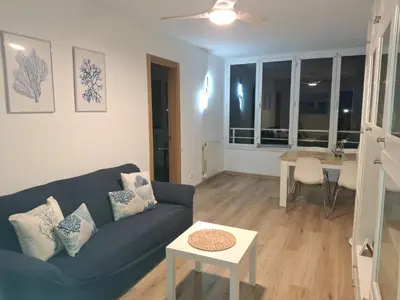 a living room with a blue couch and a table at Candela's Beach Port in Masnou