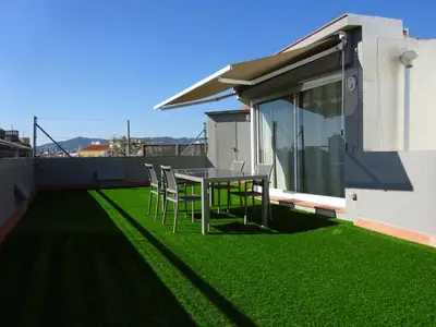 a patio with a table and chairs on the grass at Fisa Rentals Shopping in Barcelona