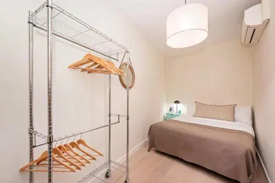 a small bedroom with a bed and a shelf at Sweett - Wellington in Barcelona
