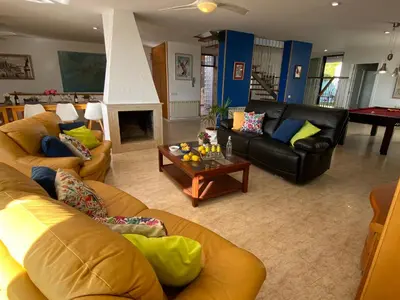 a living room with two couches and a fireplace at Villa Med A 2 kilometros andando de la playa, del puerto de Aguadoç y a 4 del centro de Sitges Muy Soleada todo el dia Capacidad superior a 16 personas NO REQUIERE COCHE in Sitges