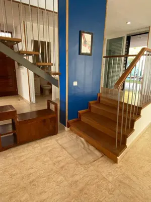a staircase in a home with blue walls and wooden stairs at Villa Med A 2 kilometros andando de la playa, del puerto de Aguadoç y a 4 del centro de Sitges Muy Soleada todo el dia Capacidad superior a 16 personas NO REQUIERE COCHE in Sitges