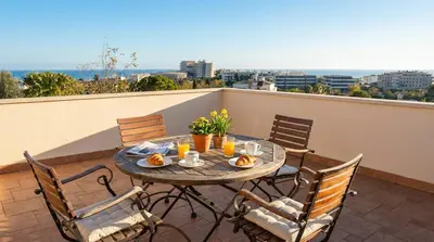 a table on a balcony with a view of the ocean at Villa Med A 2 kilometros andando de la playa, del puerto de Aguadoç y a 4 del centro de Sitges Muy Soleada todo el dia Capacidad superior a 16 personas NO REQUIERE COCHE in Sitges