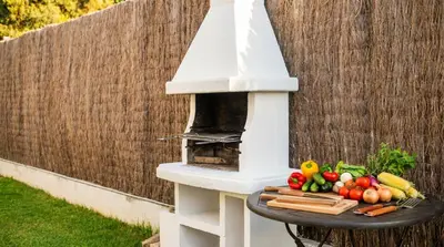 a white outdoor oven with vegetables on a table at Villa Med A 2 kilometros andando de la playa, del puerto de Aguadoç y a 4 del centro de Sitges Muy Soleada todo el dia Capacidad superior a 16 personas NO REQUIERE COCHE in Sitges