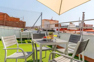 a table and chairs on the roof of a building at Canela Homes BARCELONA MACBA in Barcelona