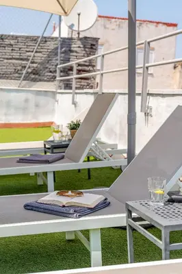 a group of tables with chairs and an umbrella at Canela Homes BARCELONA MACBA in Barcelona