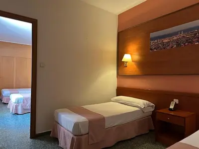a hotel room with two beds and a mirror at Cuatro Naciones in Barcelona