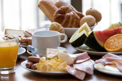 a table topped with plates of breakfast foods and orange juice at Cuatro Naciones in Barcelona