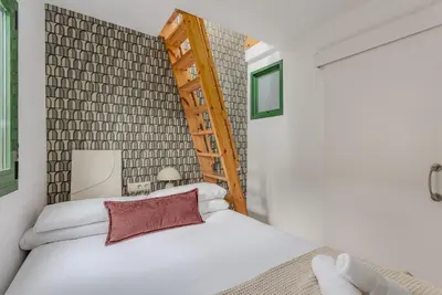 a bedroom with a white bed with a wooden headboard at Ola Living Vidreria in Barcelona
