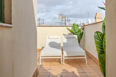 a pair of white chairs sitting on a balcony at Ola Living Vidreria in Barcelona