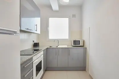 a white kitchen with a sink and a window at Fisa Rentals Aribau in Barcelona