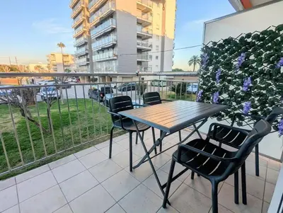 a table and chairs on a balcony with a view of a parking lot at Spacious apartment in Cabrera de Mar with sea view in Cabrera de Mar