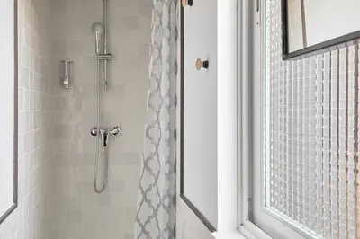 a shower in a bathroom with a shower curtain at Cal Mateu 11 huéspedes - Sagrada Família in Barcelona