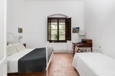a bedroom with two beds and a window at Can Rovira - Stunning Neoclassical Mansion, Just 20 min drive from Barcelona City Center, Ideal for groups and families in Alella