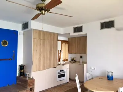 a kitchen with a ceiling fan and a wooden table at The Magic Sea Front by Hello Homes Sitges in Sitges