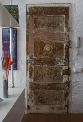 an old wooden door in the corner of a room at Loft en Gràcia ArchsenseApartments in Barcelona