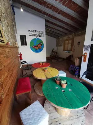 a room with two wooden tables and chairs at Mucha Masia Hostel Rural Urba in El Prat de Llobregat