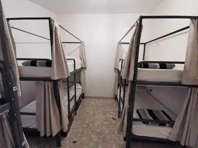 a room with three bunk beds in a room at Mucha Masia Hostel Rural Urba in El Prat de Llobregat